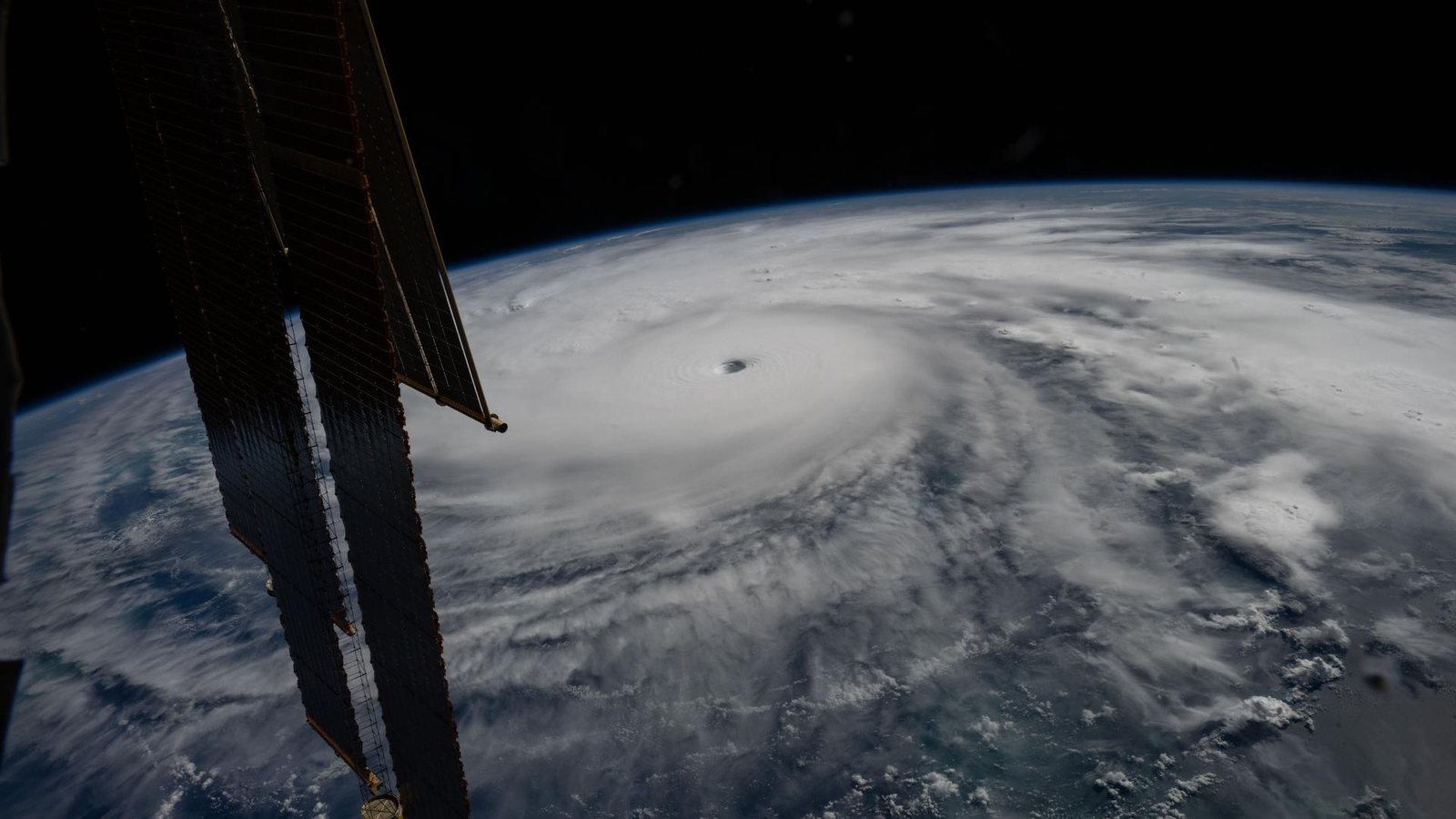 Hurricane Melissa seen from the International Space Station: a tight white spiral with a clear eye over the Caribbean Sea, with the station's solar arrays in the foreground.